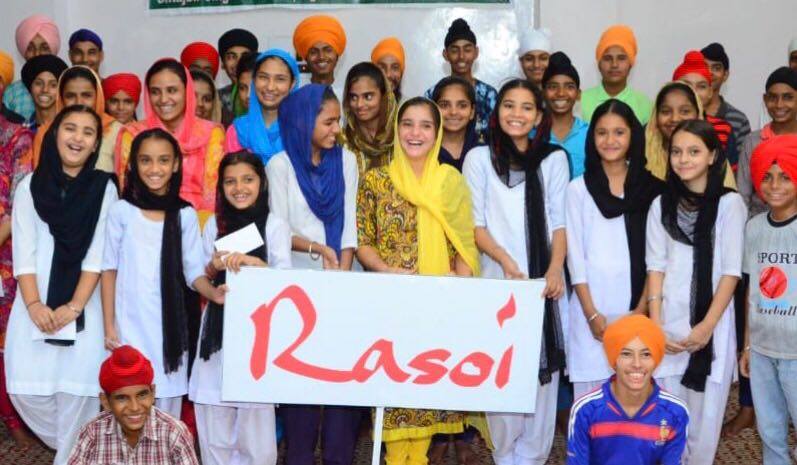 Children in India holding the Rasoi sign — sponsored through school by Rasoi